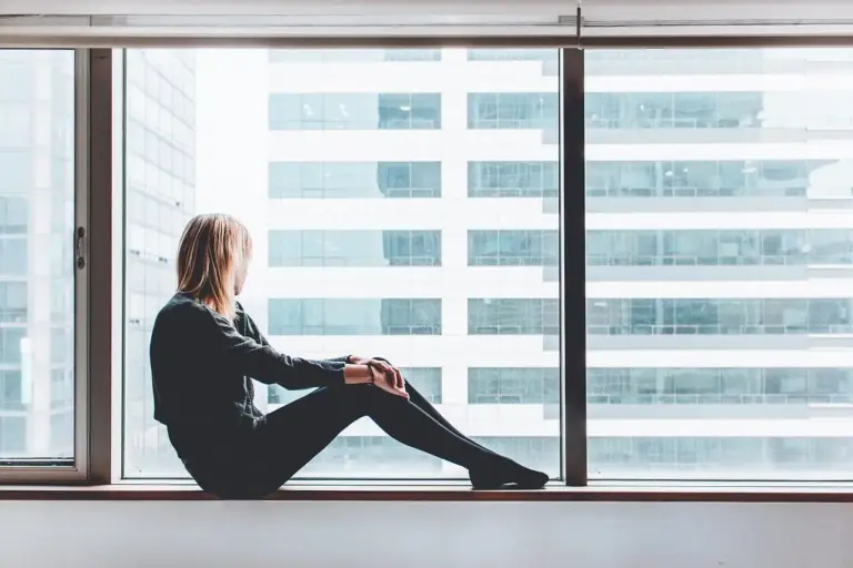 Woman looking out of building window.